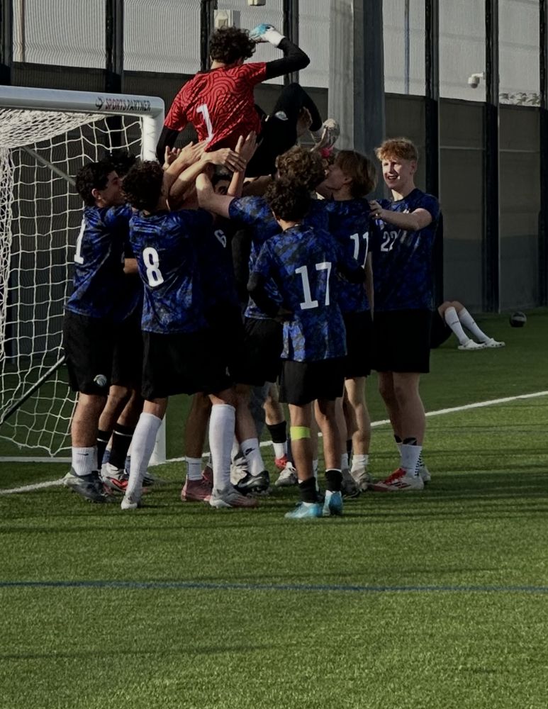 AISR players lifting their goalkeeper after a win