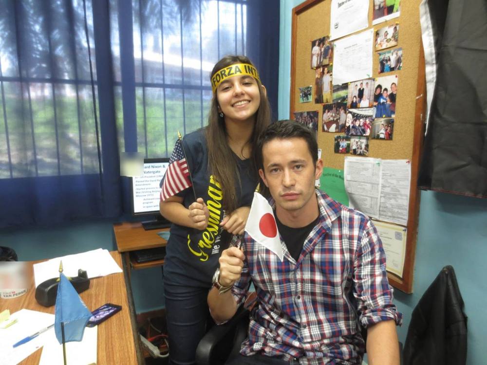 Nick at his desk in Honduras with a student