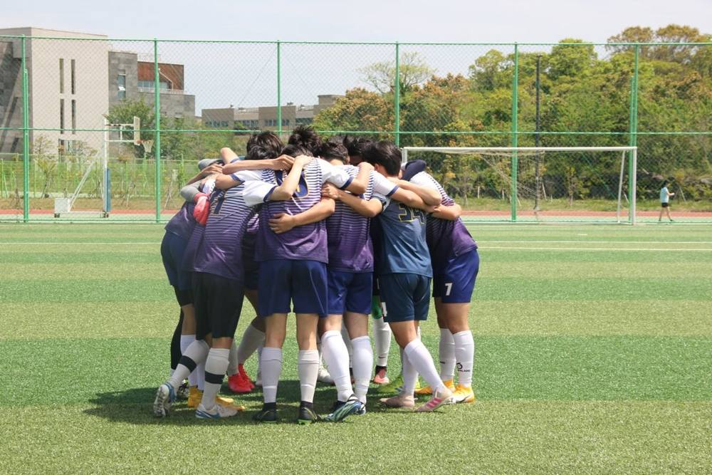 KISJ boys soccer team huddle